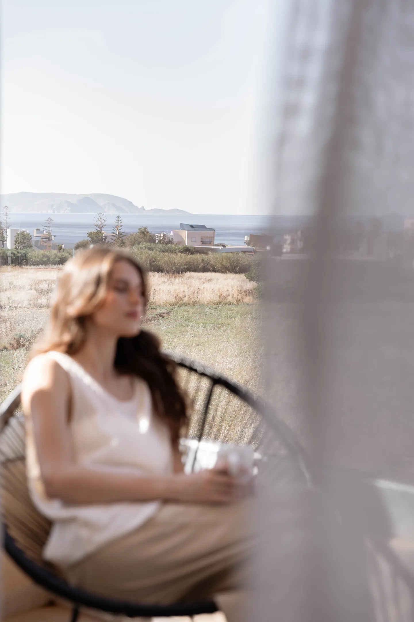 Guest enjoying a coffee in the morning sun beside the bouclé sofa