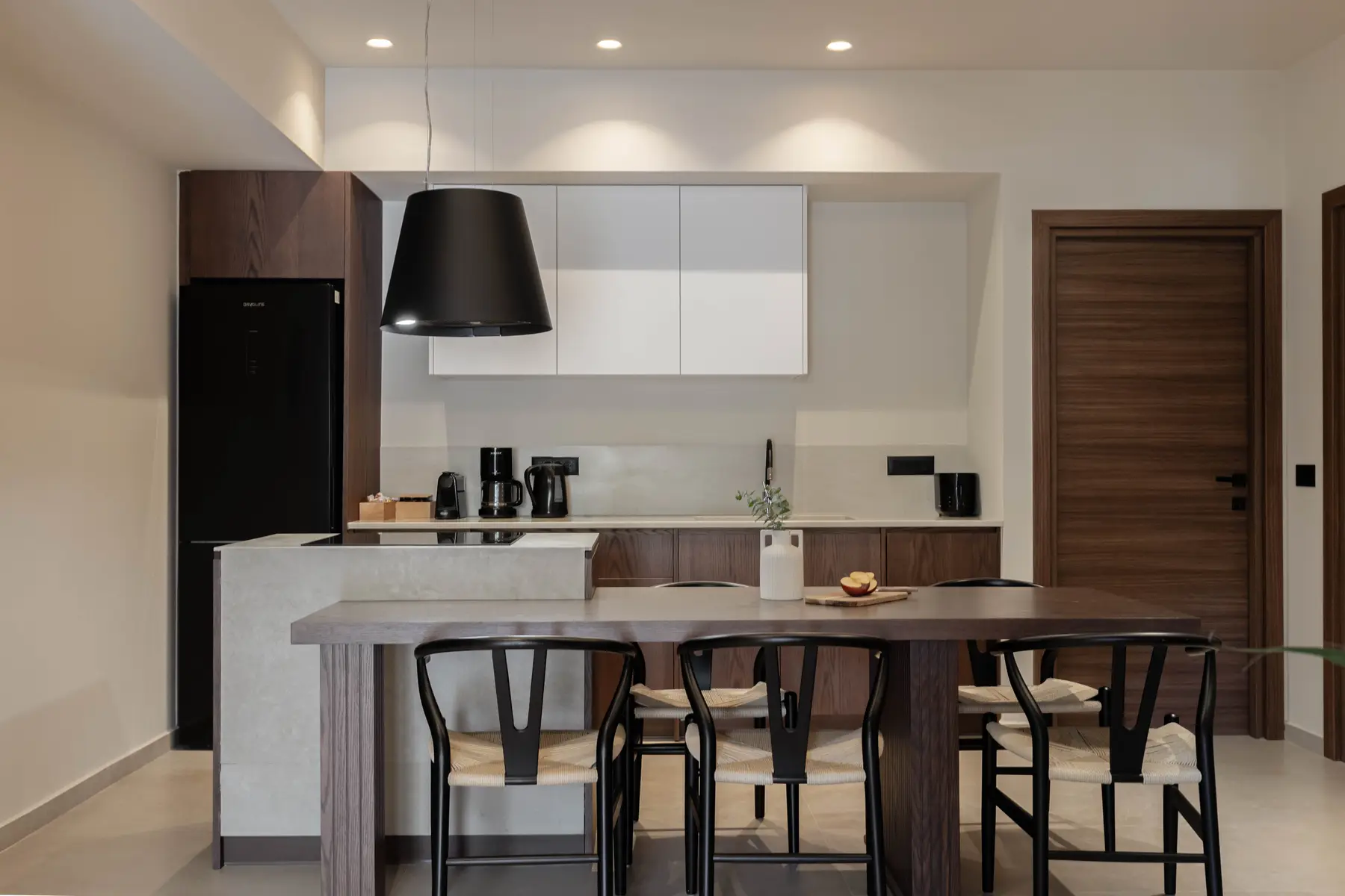 Dark oak kitchen of the Superior Suite with bar table and wishbone stools