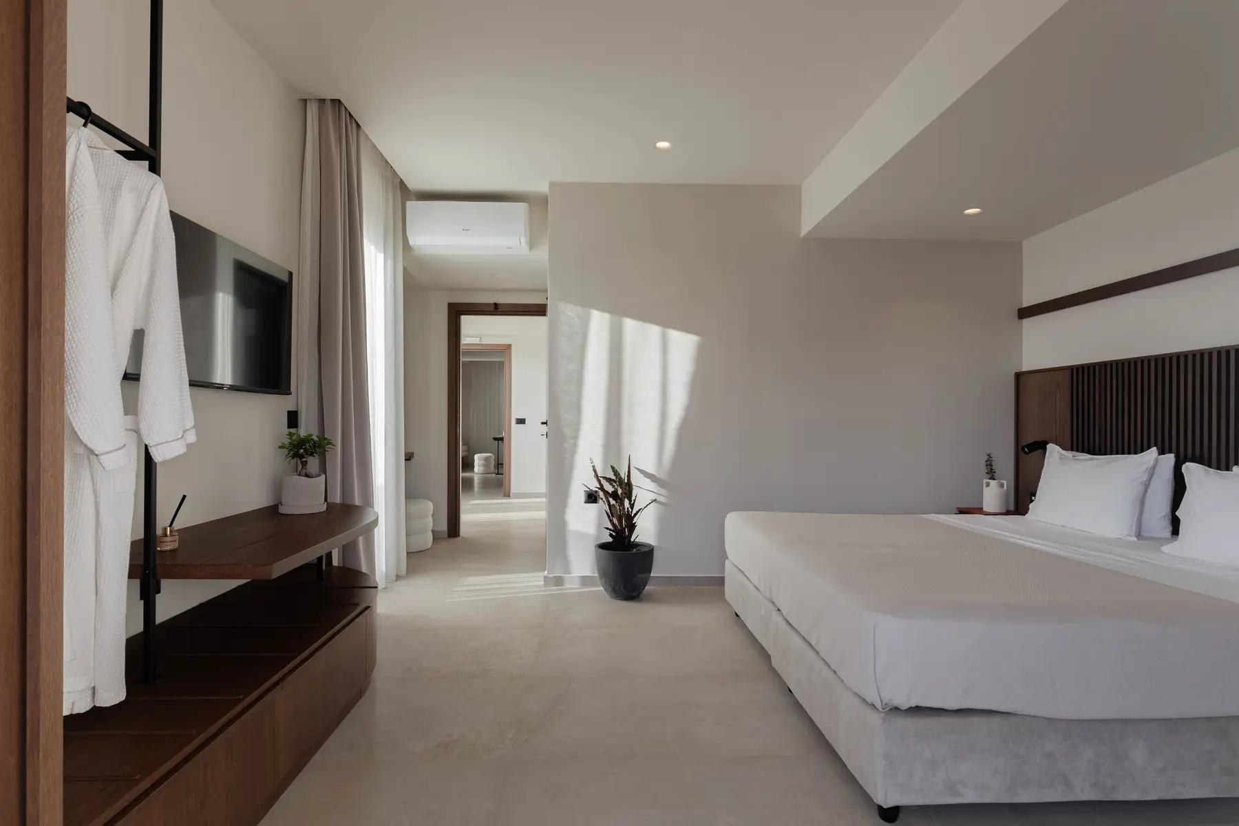 Master bedroom with TV wall and the corridor beyond