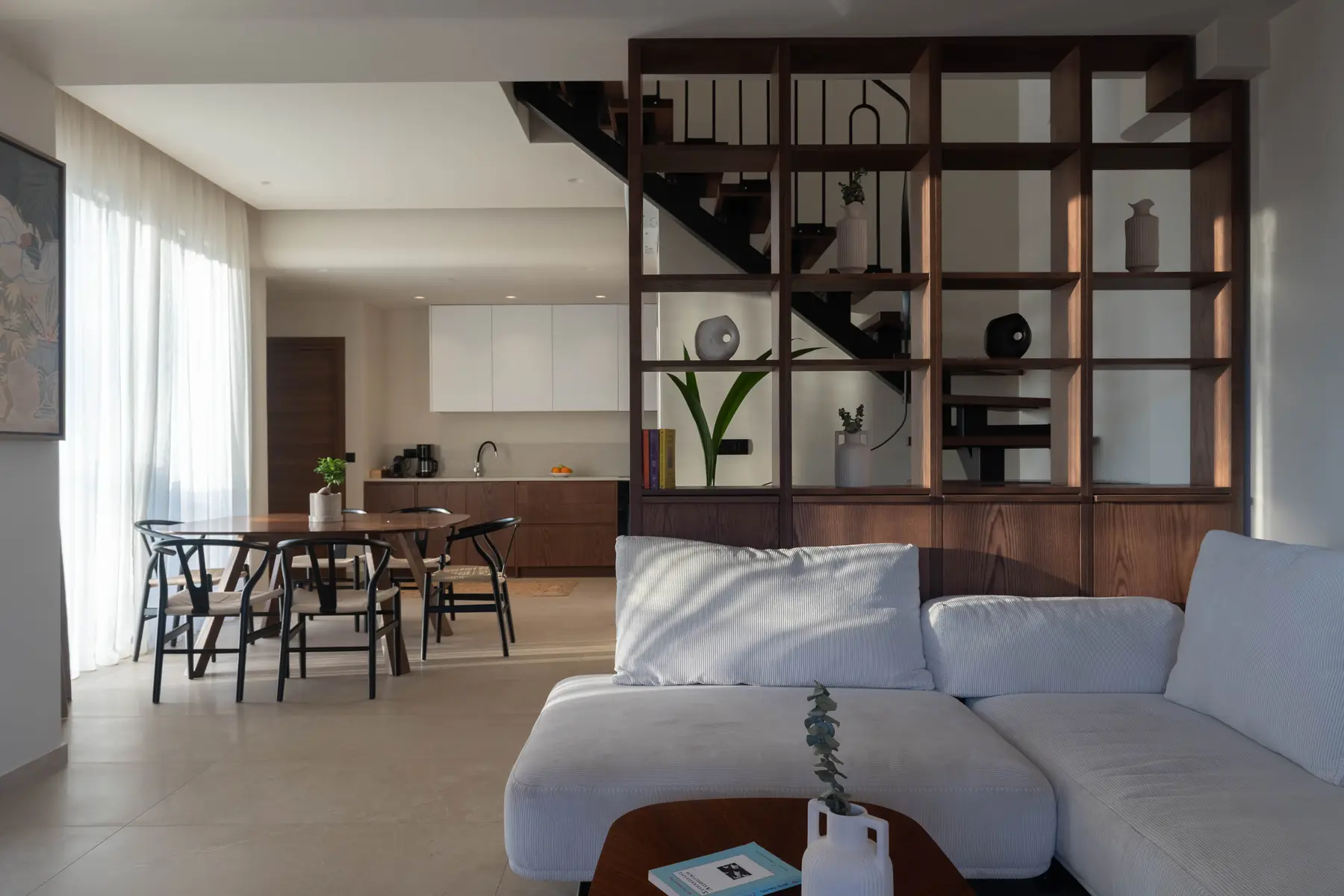 Living room of the Deluxe Suite with oak shelving, dining table and staircase