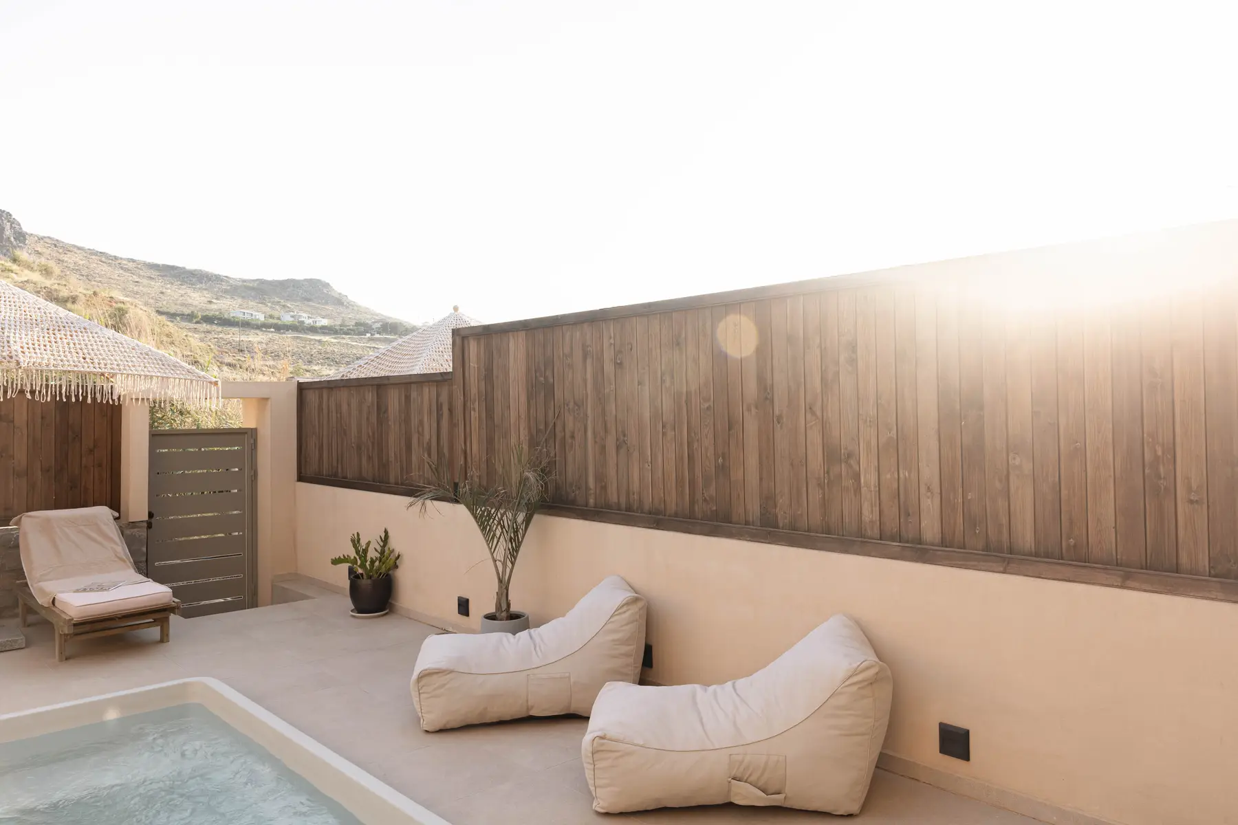 Sun loungers by the pool wall in the evening light